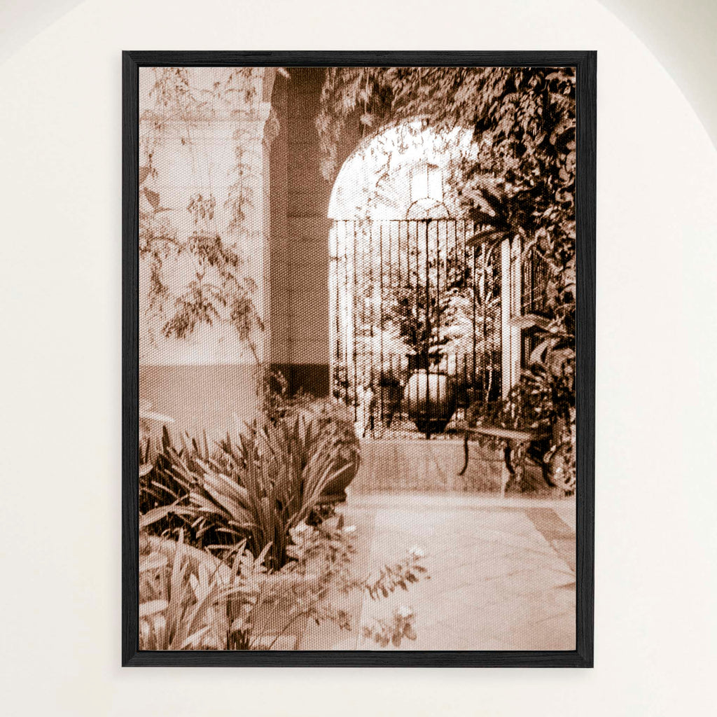 Sepia photograph of a shaded Spanish Colonial monastery patio filled with tropical plants, framed in oak. Close view.