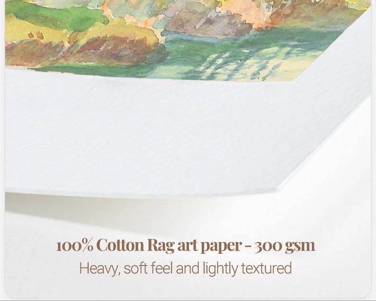 A close-up of a watercolor landscape painting printed on textured white art paper, with text below reading '100% Cotton Rag art paper - 300 gsm' and 'Heavy, soft feel and lightly textured'.